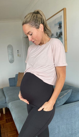 Nurse Aimee in TheRY saviour compression leggings in 3rd trimester with hands in pockets