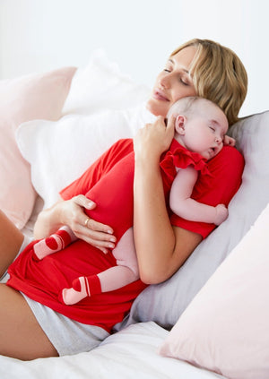 Thery Group TEE Lucky red The Me Bamboo Slouch Tee  - side view new mother cradling baby on bed