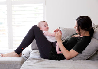 TheRY black Bamboo Me Slouch Tee on postpartum mother with baby side view